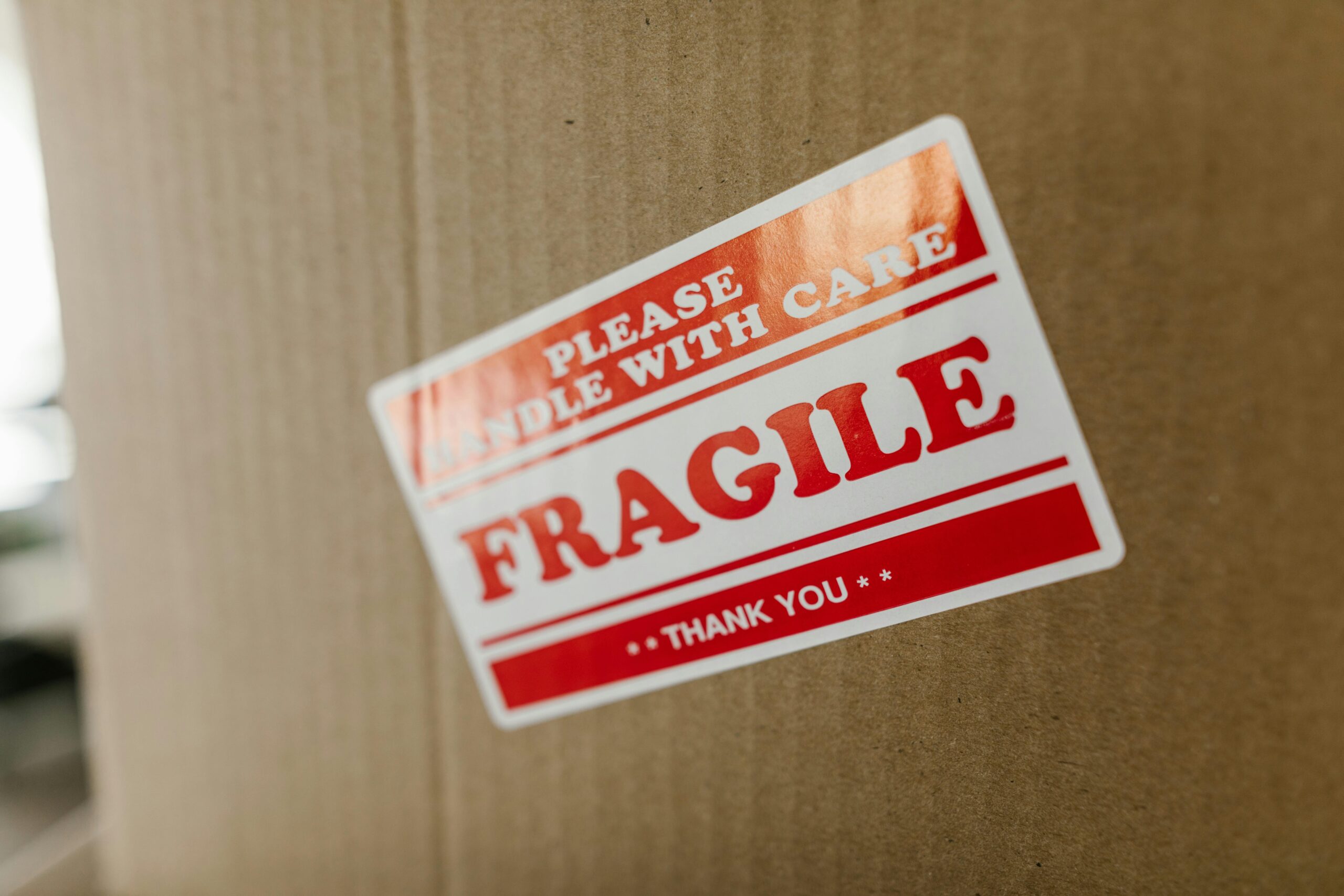 pexels-photo-7464680-7464680 Close-up of a cardboard box with a 'fragile' sticker indicating careful handling.